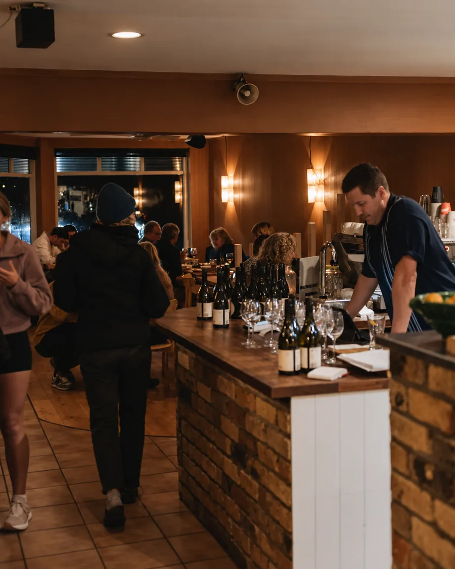 The cafe counter filled with guests during an evening service